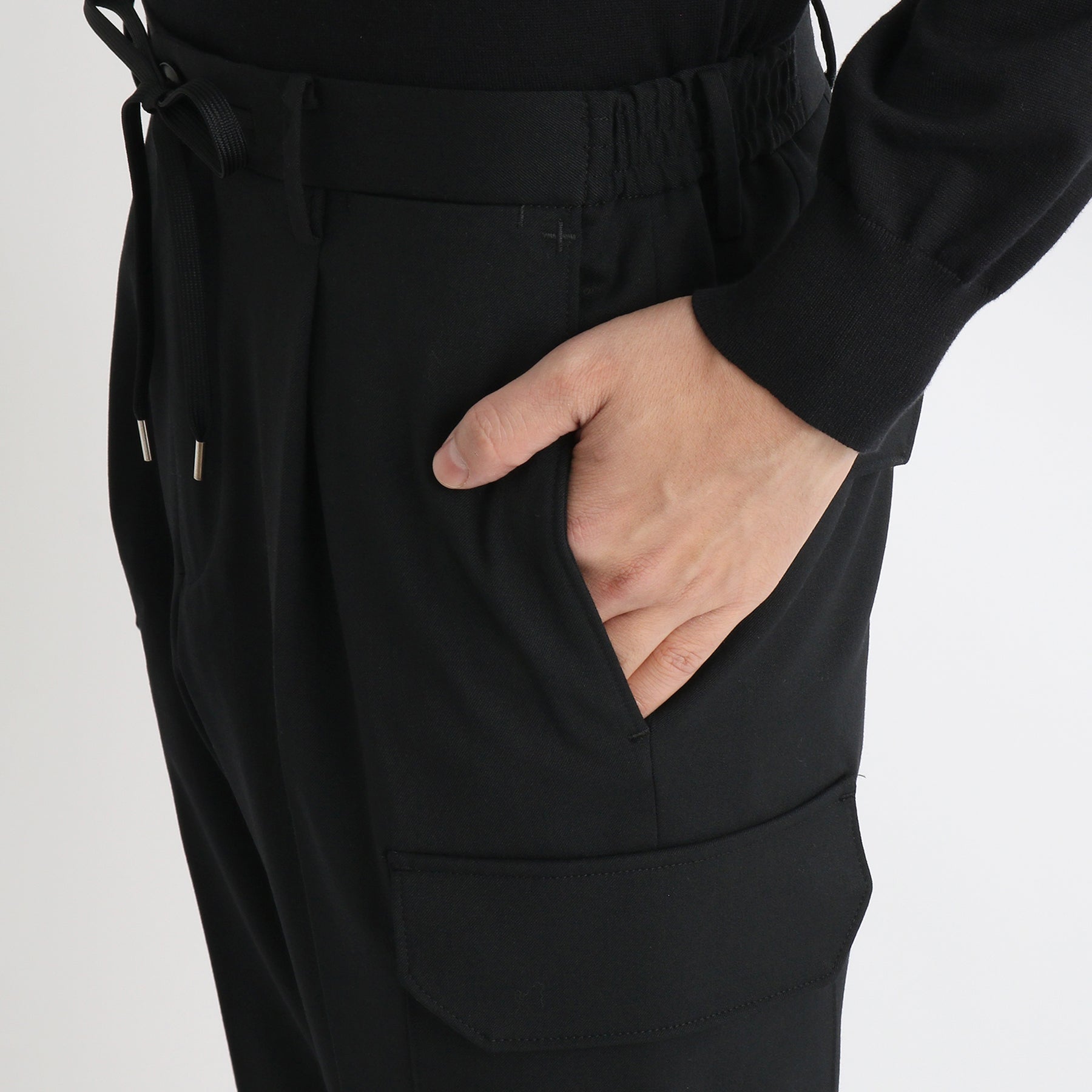 ストレッチカーゴトラウザーブラックの側面ポケットを写したメンズ着用画像