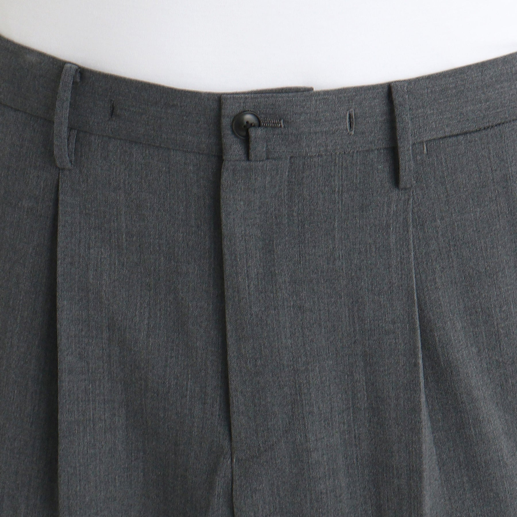 ストレッチカーゴトラウザーチャコールのウエストボタン部分を写したメンズ着用画像