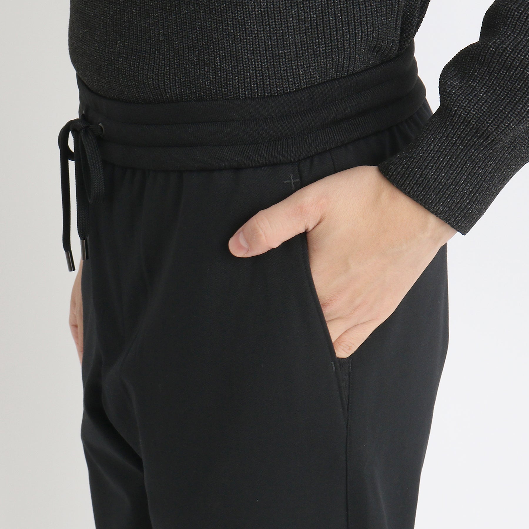 テックウールジョガーパンツブラックのポケットを写したメンズ着用画像