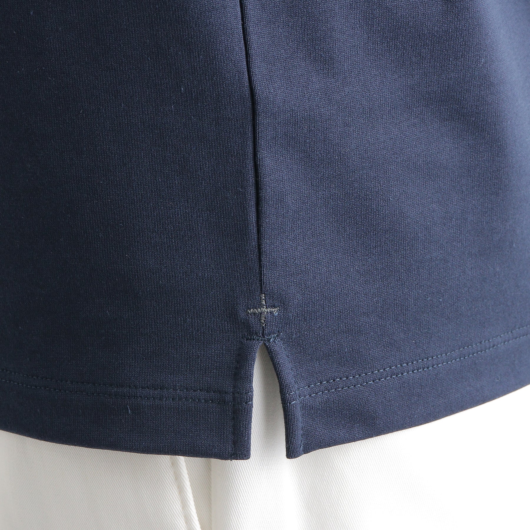 ハイブリッドコットンバスクシャツネイビーの裾を写したメンズ着用画像