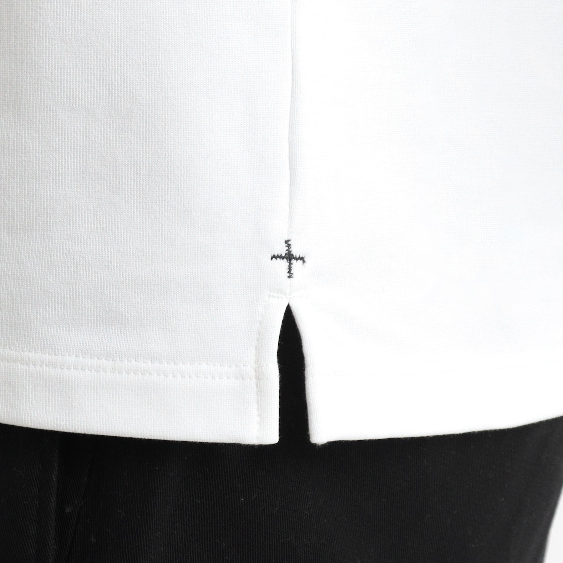 ハイブリッドコットンバスクシャツホワイトの裾を写したメンズ着用画像