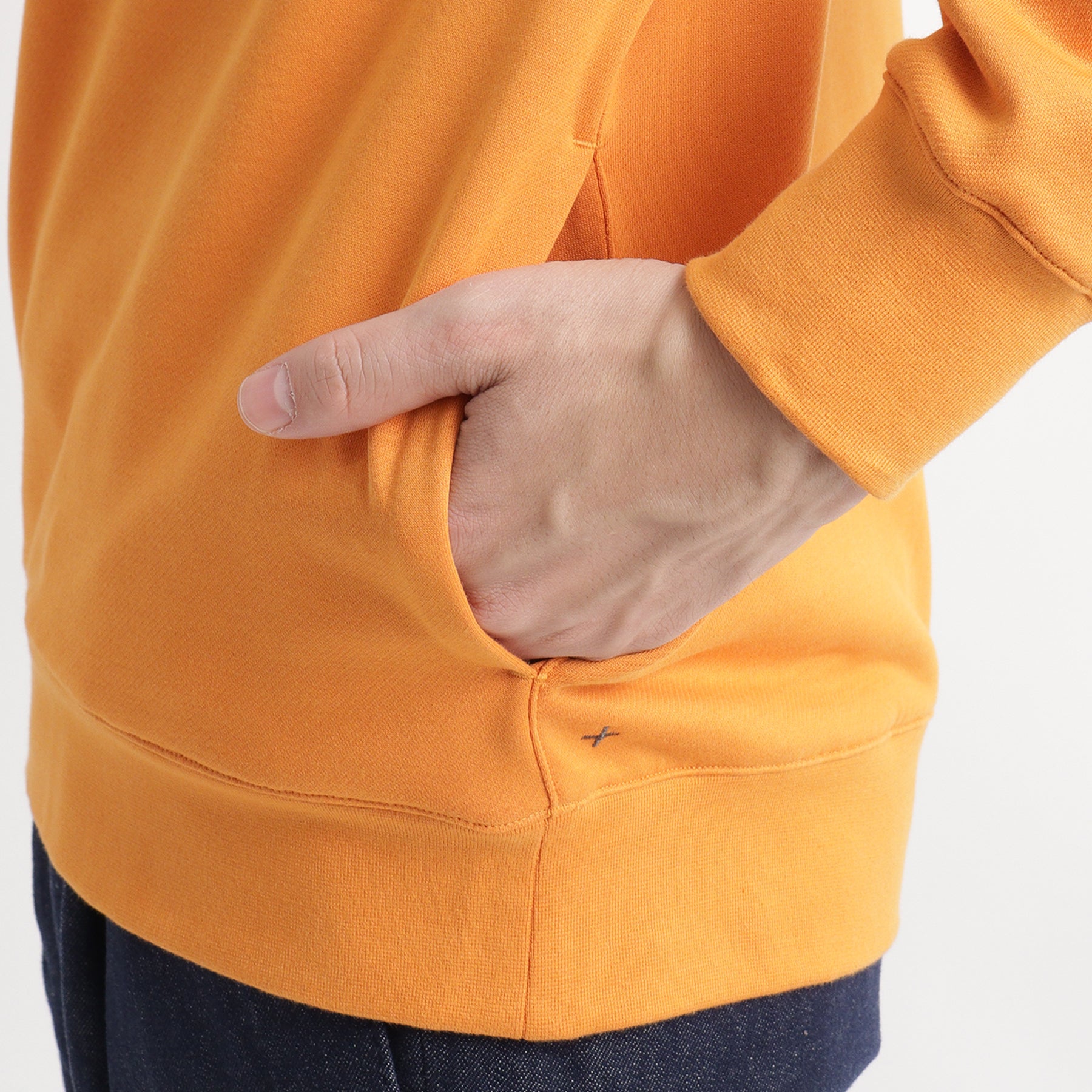 スビンプラチナム裏毛フーディーアンバーオレンジのポケットを写したメンズ着用画像