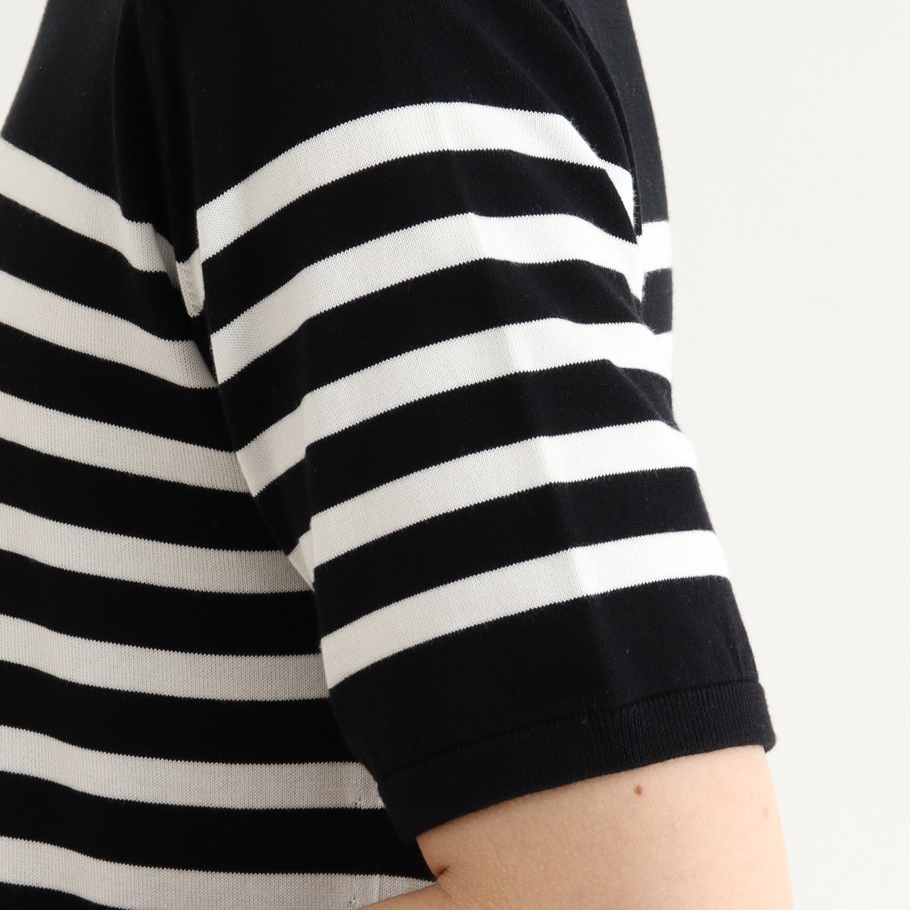 スビンプラチナムボーダーニットブラックホワイトの袖を写したメンズ着用画像