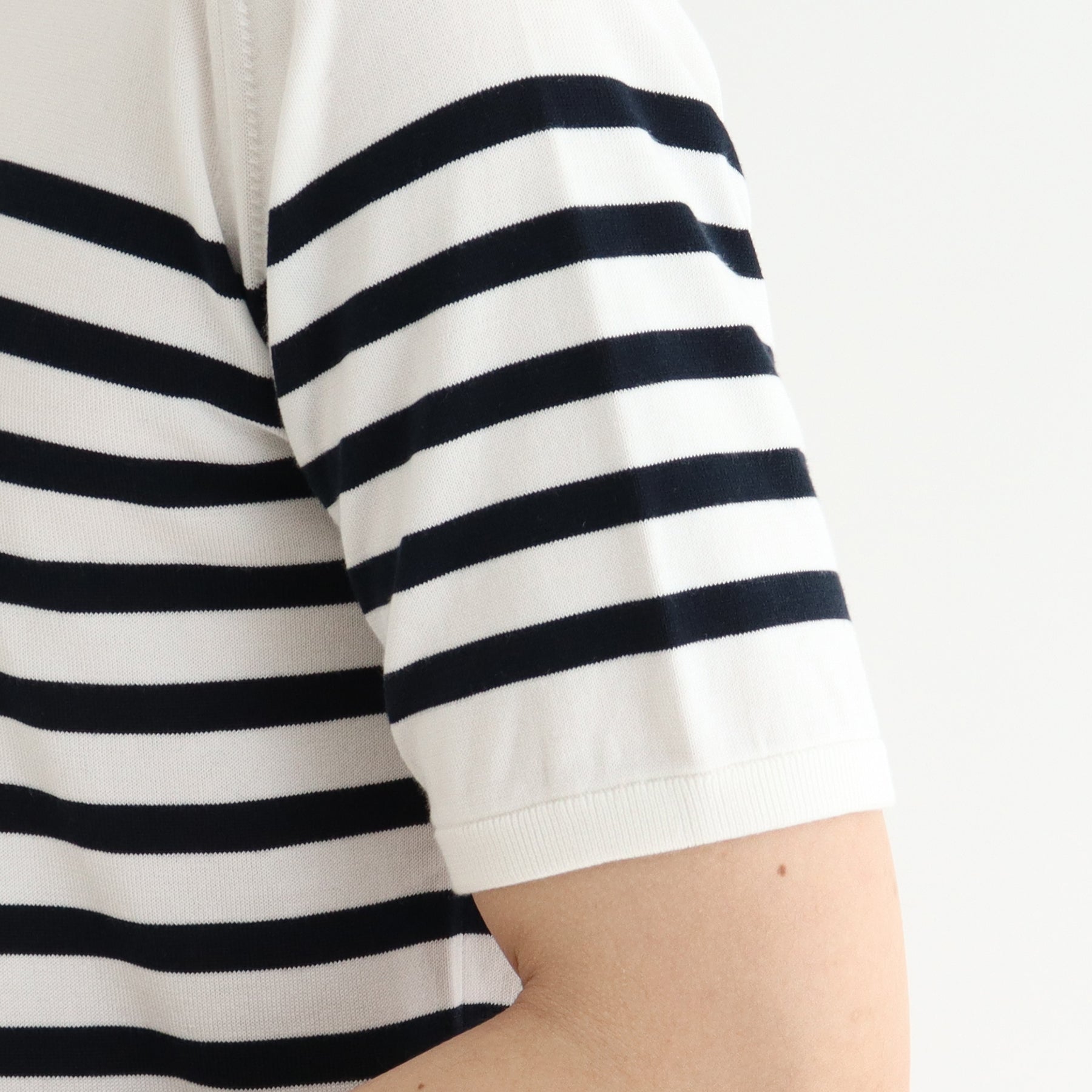 スビンプラチナムボーダーニットホワイトネイビーの袖を写したメンズ着用画像