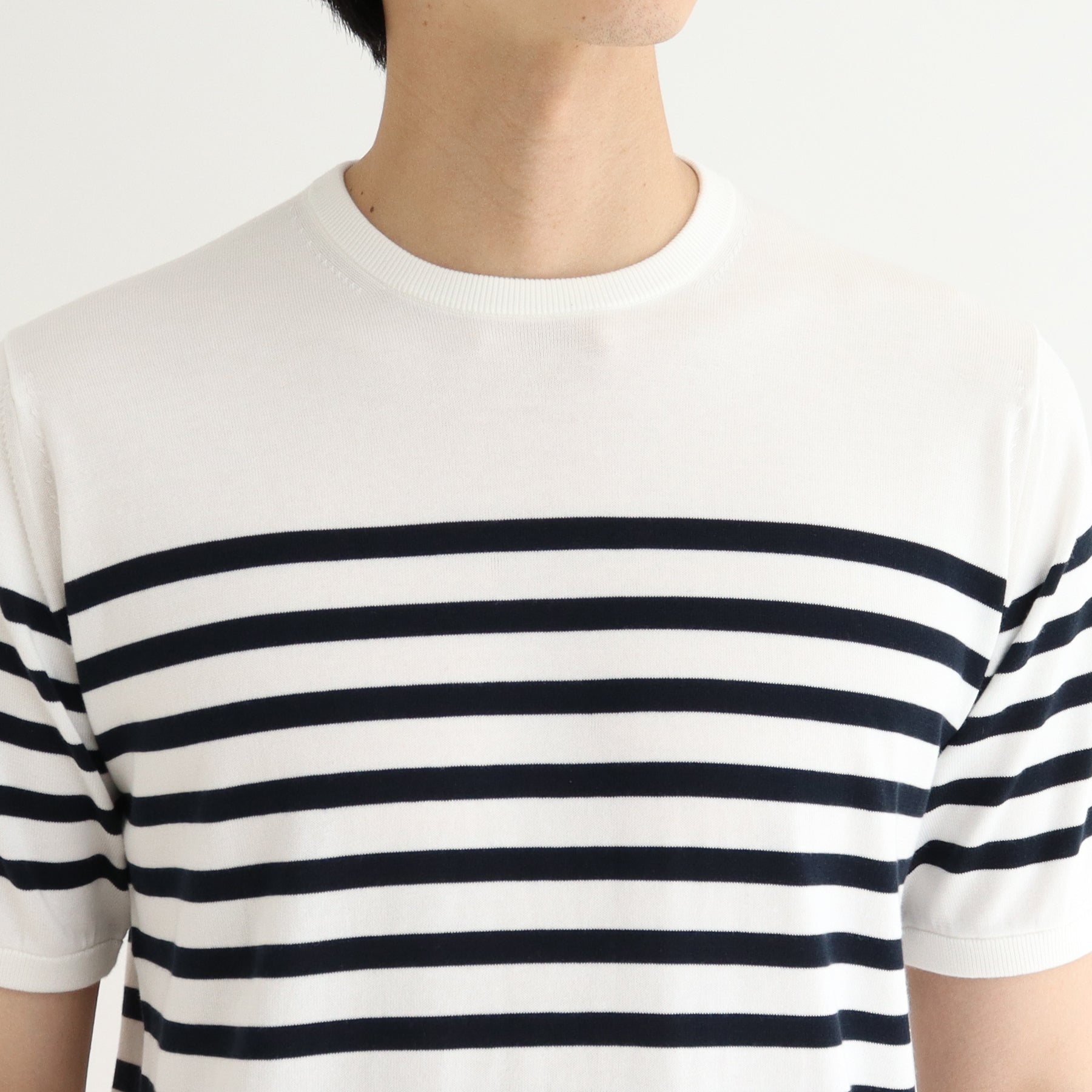 スビンプラチナムボーダーニットホワイトネイビーの首まわりを写したメンズ着用画像