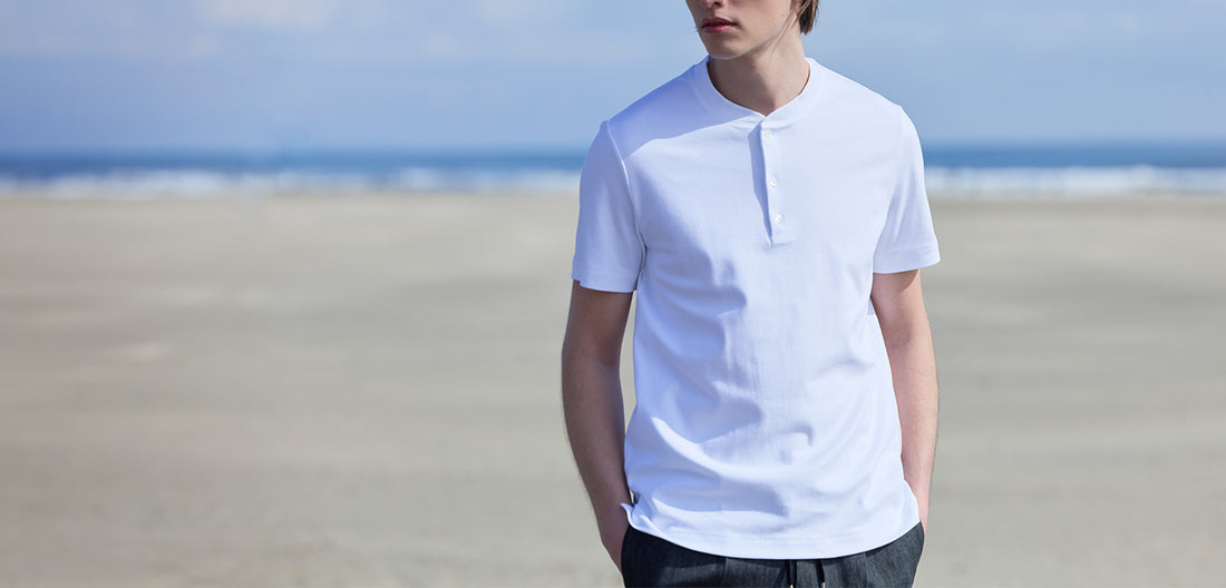 白いヘンリーネックTシャツを着たモデル