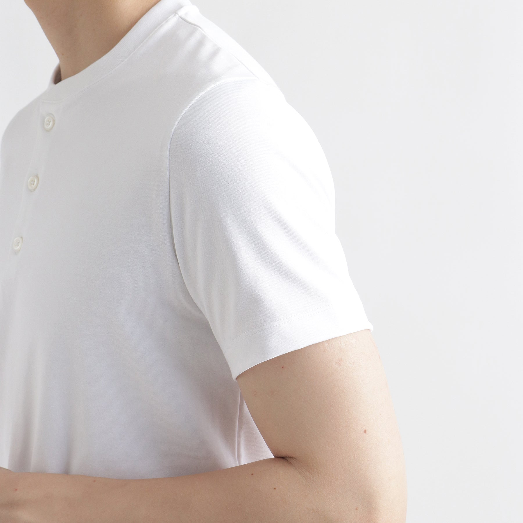 ハイブリッドコットンヘンリーネックテーラードTシャツホワイトの袖を写したメンズ着用画像