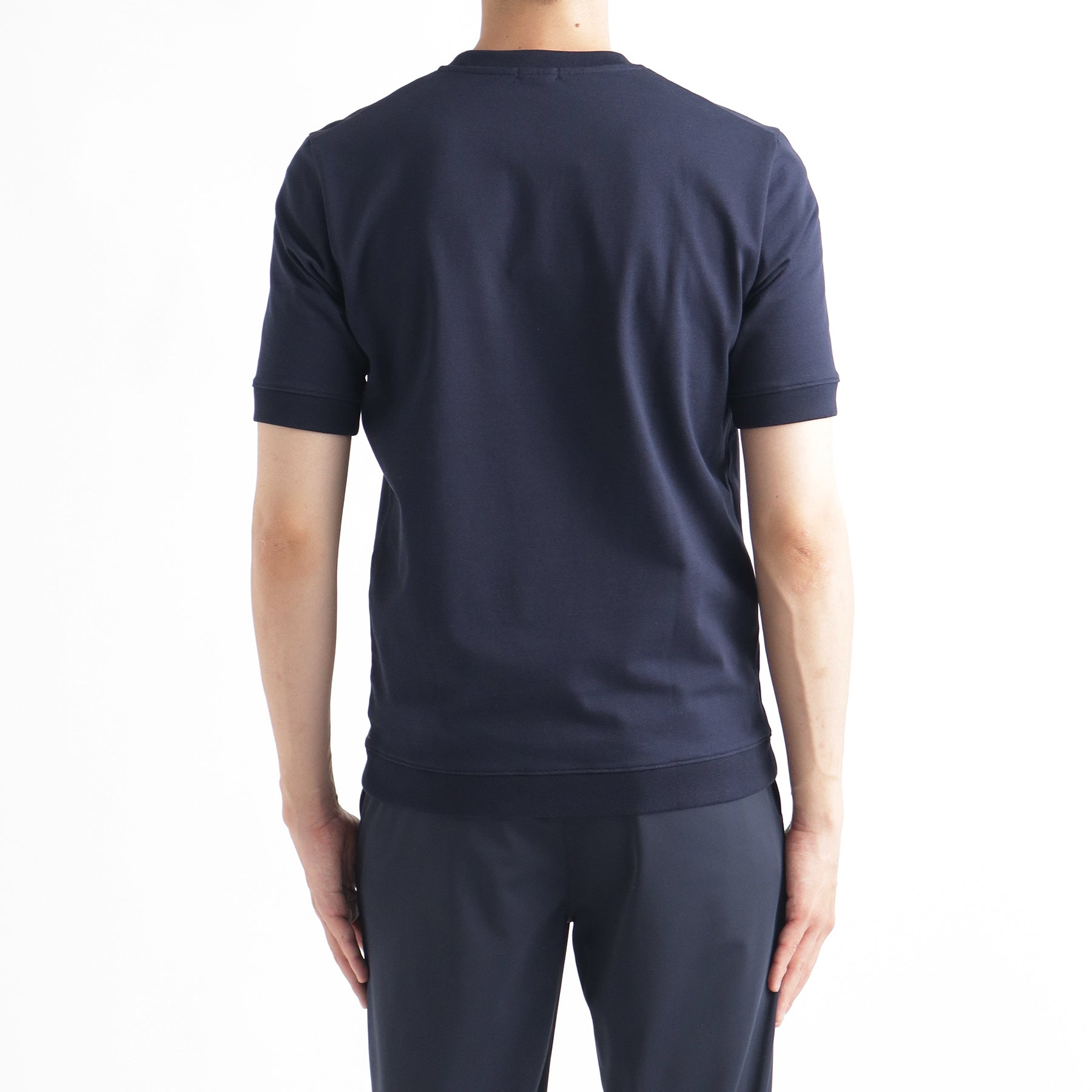 ハイブリッドコットンリブドヘムテーラードTシャツネイビーの背面を写したメンズ着用画像