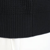 ミドルゲージクルーネックニットブラックの裾を写したメンズ着用画像