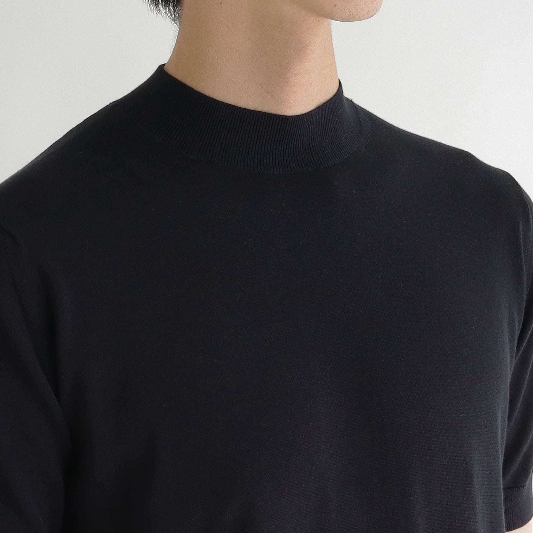 スビンプラチナムモックネックニットブラックの首まわりを写したメンズ着用画像