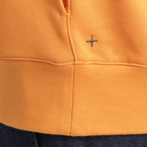 スビンプラチナム裏毛フーディーアンバーオレンジの裾を写したメンズ着用画像