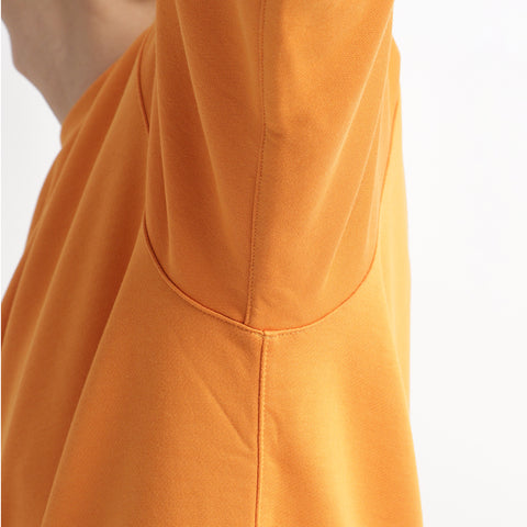 スヴィンプラチナム裏毛スウェットシャツアンバーオレンジのうで周りを写したメンズ着用画像