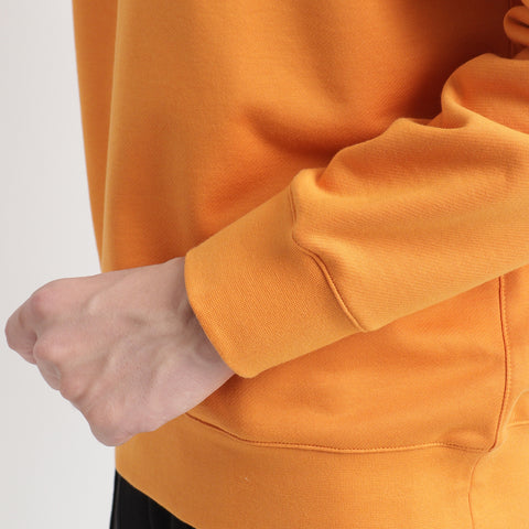スヴィンプラチナム裏毛スウェットシャツアンバーオレンジの袖を写したメンズ着用画像