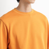 スヴィンプラチナム裏毛スウェットシャツアンバーオレンジの首周りを写したメンズ着用画像
